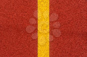 Closeup of the yellow line on red stadium running track