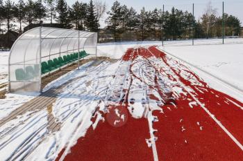 Sports stadium in the winter. The running track of a stadium in winter, surrounded by snow.