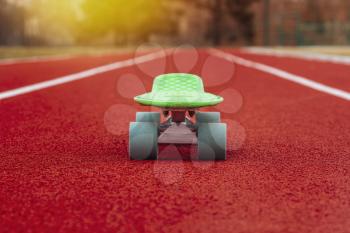 Green penny board stands on the run track in the school stadium