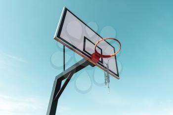 Broken basketball basket outside on blue sky background