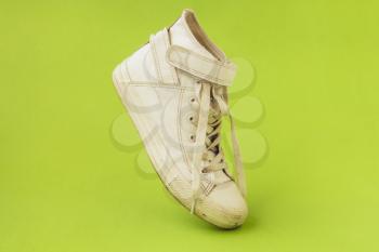 White dirty shoe on the green background