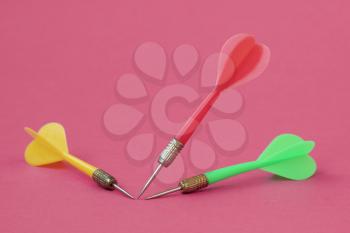 Three colored dart arrows on the pink background