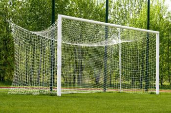 Empty football goals on the soccer field with green grass