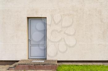 Grey metallic door in wall of industrial building.Copy space.