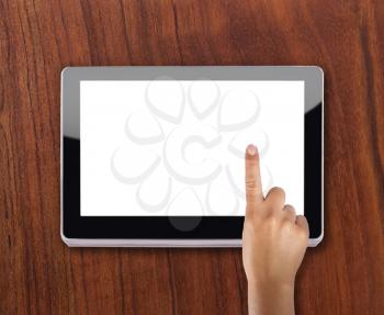 Modern tablet device over wooden background with index finger touching screen