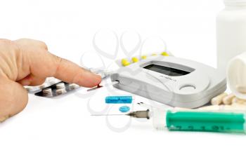 Royalty Free Photo of a Machine for Measuring Blood Sugar With a Hand and a Needle