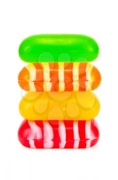 Four pieces of soap in red, yellow, green and orange with a pattern isolated on a white background