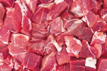 The texture of raw red meat pieces with white streaks of fat