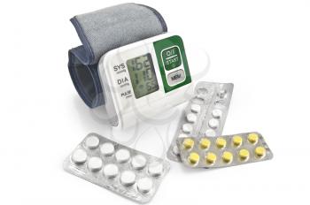 Electronic blood pressure monitor for a hand with pills in the package is isolated on a white background