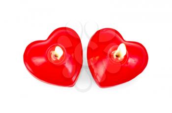 Two burning red candles in the shape of a heart isolated on white background
