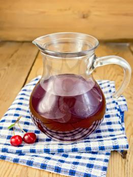 Cherry compote in a glass jar, napkin, two berries on a branch on a wooden boards background