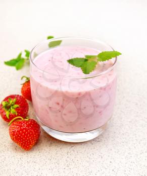 Milk cocktail with strawberries, mint on the background of a granite table
