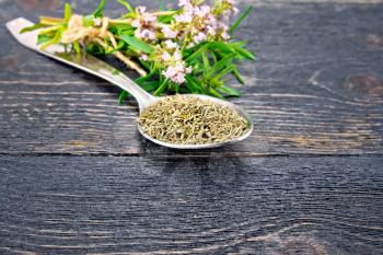 Thyme dry in a metal spoon, a bunch of fresh herbs with flowers on the background of a black wooden board