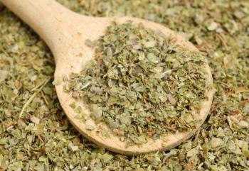 Dried marjoram spice and wood spoon as food background 

