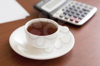Royalty Free Photo of a Cup of Tea and a Calculator