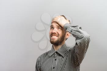 Closeup portrait, goofy, silly young man, slapping hand on head . Negative human emotion facial expression feelings, body language