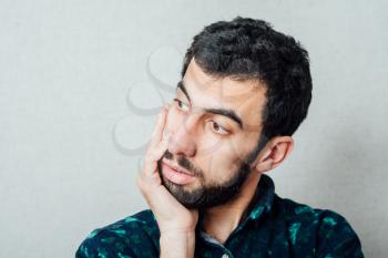 a young man with a beard feels frustrated