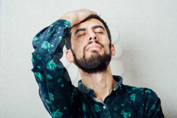 Young Man with Beard suffering Headache, stressed, frustrated.