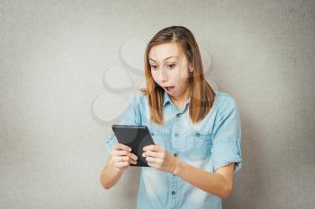 girl looking into a tablet and shocked