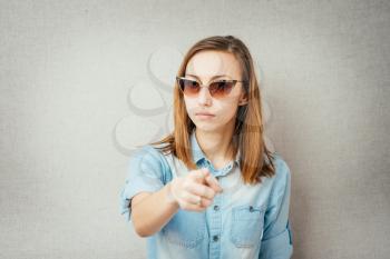 girl with glasses pointing her finger