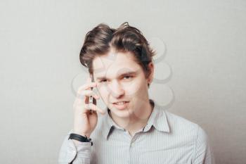Portrait of young pensive businessman talking on cell phone
