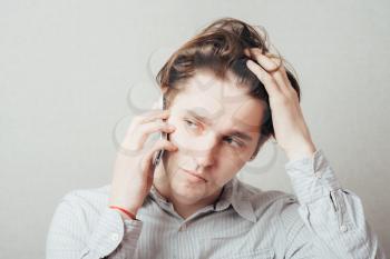 man talking on the phone and holding his head