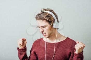 Man in headphones listening to music. On a gray background.