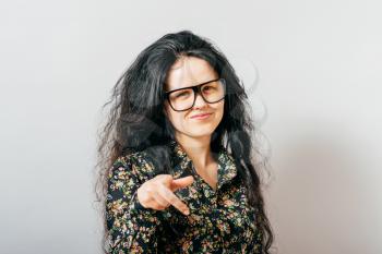young woman with glasses and pointing at you.