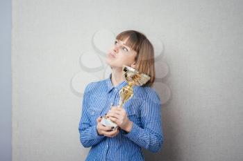 Half-length portrait of business woman keeping gold cup, isolated on white. Concept of victory and success