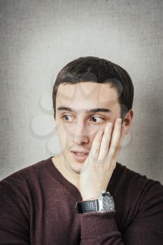 young man in shock with hands on face