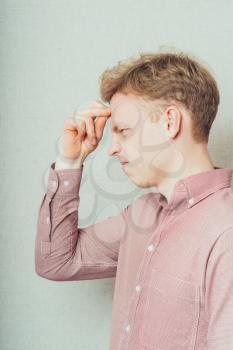 young man thinking with hand on face