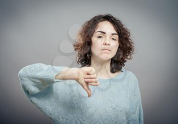 Closeup portrait angry mad upset pissed young woman, showing loser sign,  giving thumbs down isolated. Negative emotion, facial expression, signs, symbols, feeling