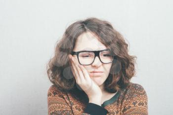 Girl has a toothache wearing glasses