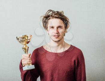a man holding a cup of the winner