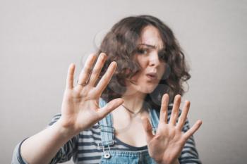 Dark haired woman making STOP gesture with hands, concept