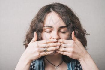 beautiful  girl covers her mouth with her hands