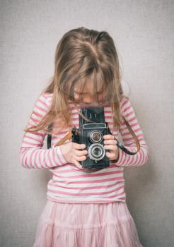  little girl shooting photo with vintage camera