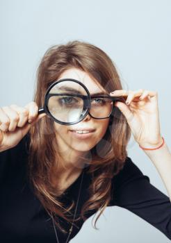 young woman looking through a magnifying glass