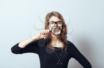 funny young woman with a magnifying glass