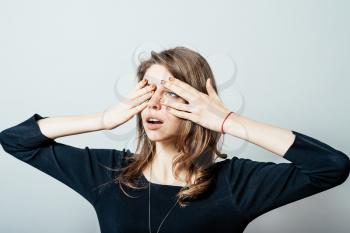 young woman closes his eyes with his hands