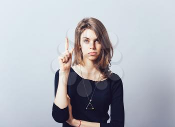 Headshot attractive business woman having good idea aha thought pointing index finger up solution found isolated on grey wall background. Human face expressions emotions body language perception
