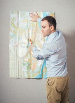 Tourist man looking at map against 
