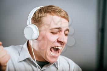 young man singing with loud music in the ears