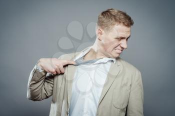 Closeup portrait of young man opening shirt to vent,it's hot. Negative emotion, facial expression, feeling