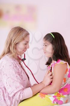 Female doctor examining little girl 
