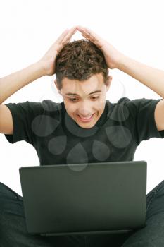 young man shocked with something he see on his laptop computer 
