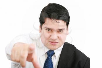 Portrait of an angry young business man in suit pointing at you isolated over white background 
