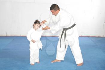Black belt Karate teaching a little girl