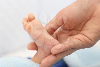 Hands holding a baby foot