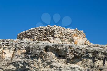 Ancient stone talayot at the cliff of the south coast of Menorca island, Spain.